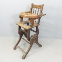 An early 20th century oak metamorphic high chair. Dimensions as chair 37x94x58cm. Tray currently