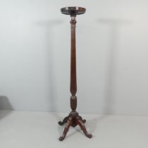A large antique mahogany torchere stand, with fluted column, raised on quadruple sabre leg base.