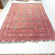 A red-ground Afghan carpet. 290x200cm.