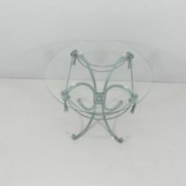 A mid-century Italian circular glass topped table on wrought metal base, with top design, flower