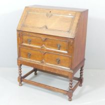 A Jacobean style oak bureau on stand. 74x101x42cm. This piece is in a single section. Some marks and