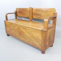 A 1930s French Art Deco hall settle in chestnut, the lift up bench seat with storage under.