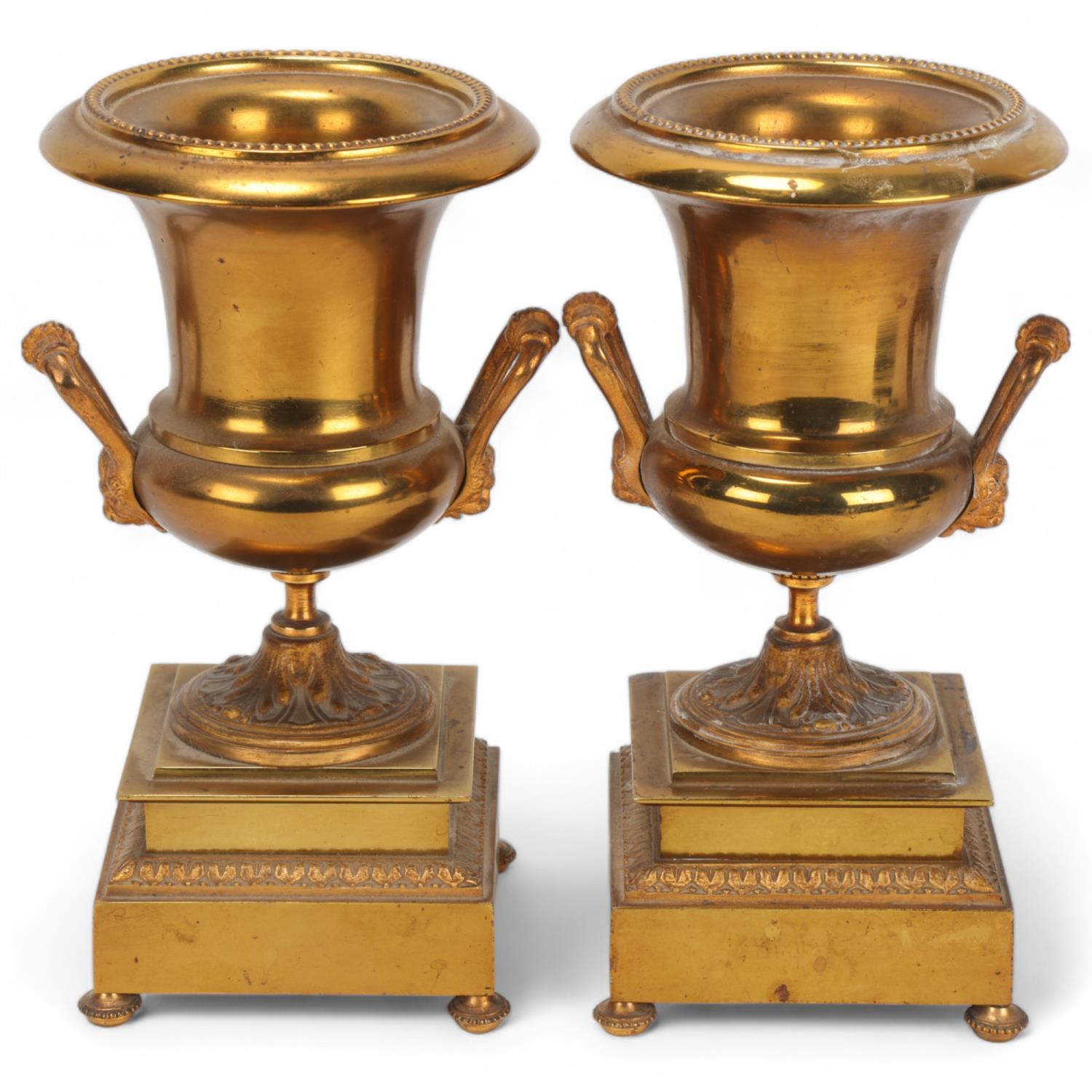 Pair of 19th century gilt-brass campagna form mantel urns on stepped plinths, height 20cm 1 foot