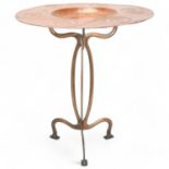 An Arts and Craft embossed copper tray on stylised brass stand, no maker's marks, diameter 42cm No