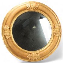 An early 19th century circular gilt cushion-framed wall mirror, with relief acanthus leaf gesso