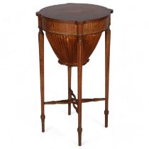 An Edwardian Sheritan style circular mahogany sewing table, with rising top and inlaid decoration,