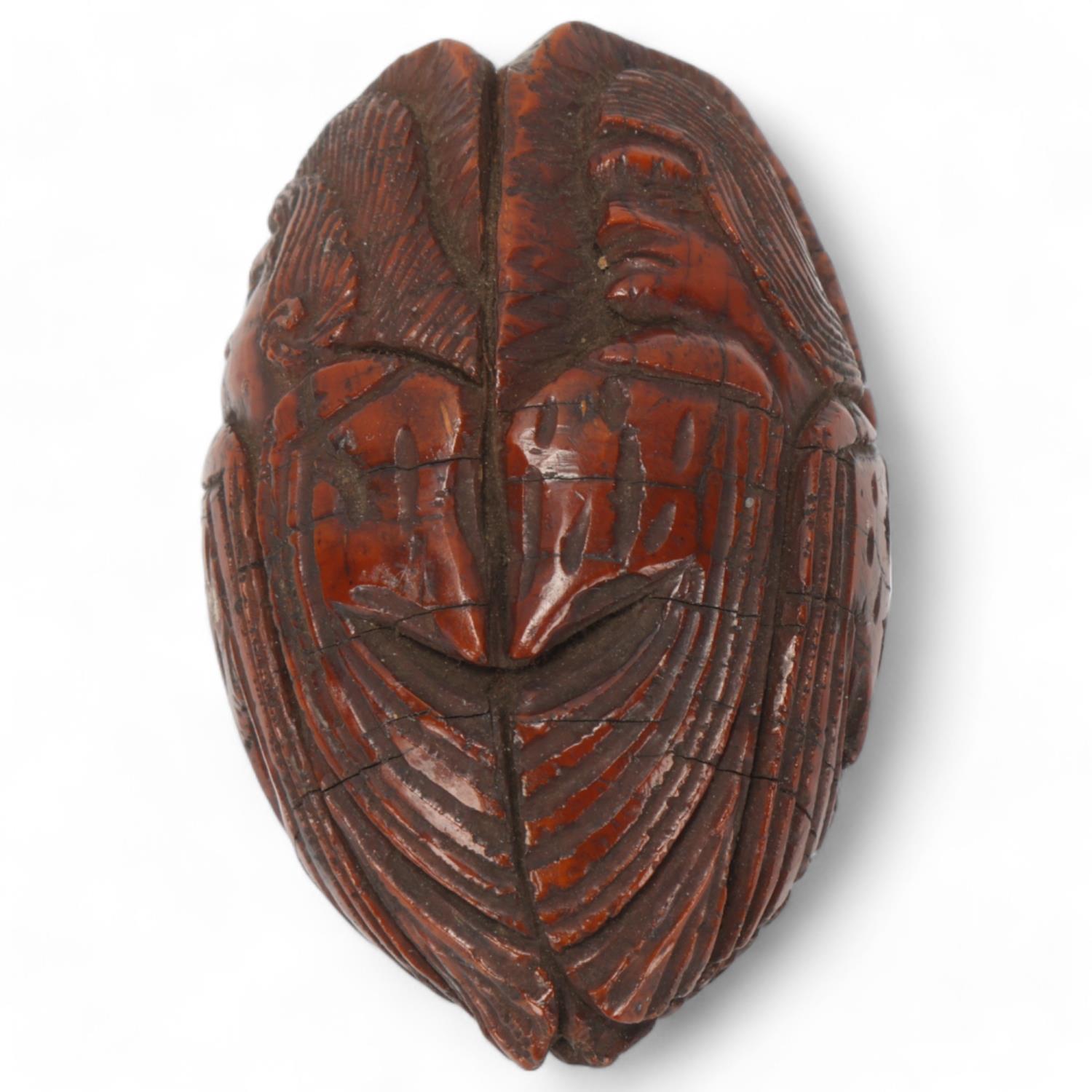 19th century coquilla nut, relief carved all round with portraits of men, length 6.5cm Several age-