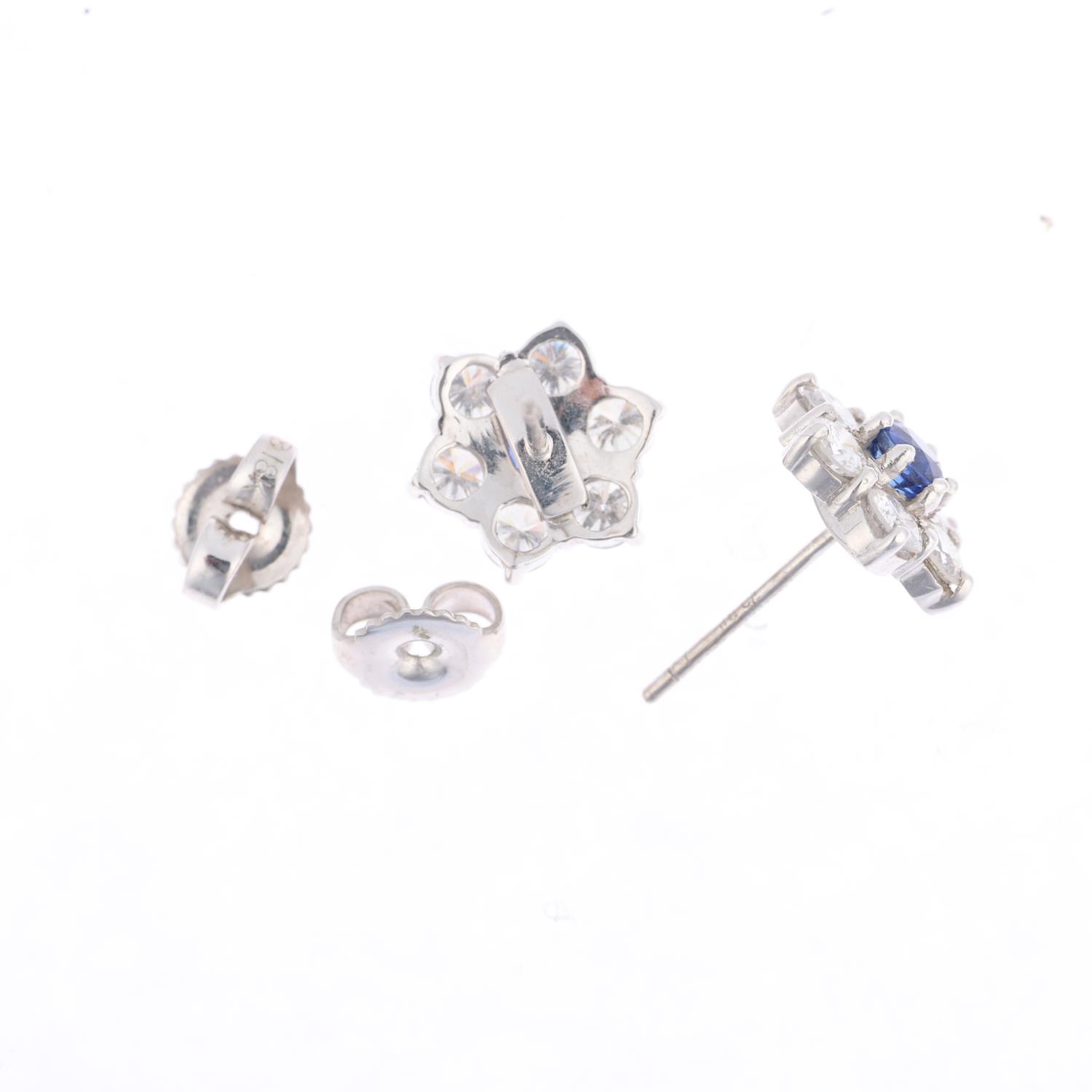A pair of 18ct white gold sapphire and diamond flowerhead cluster earrings, claw set with round- - Image 2 of 3