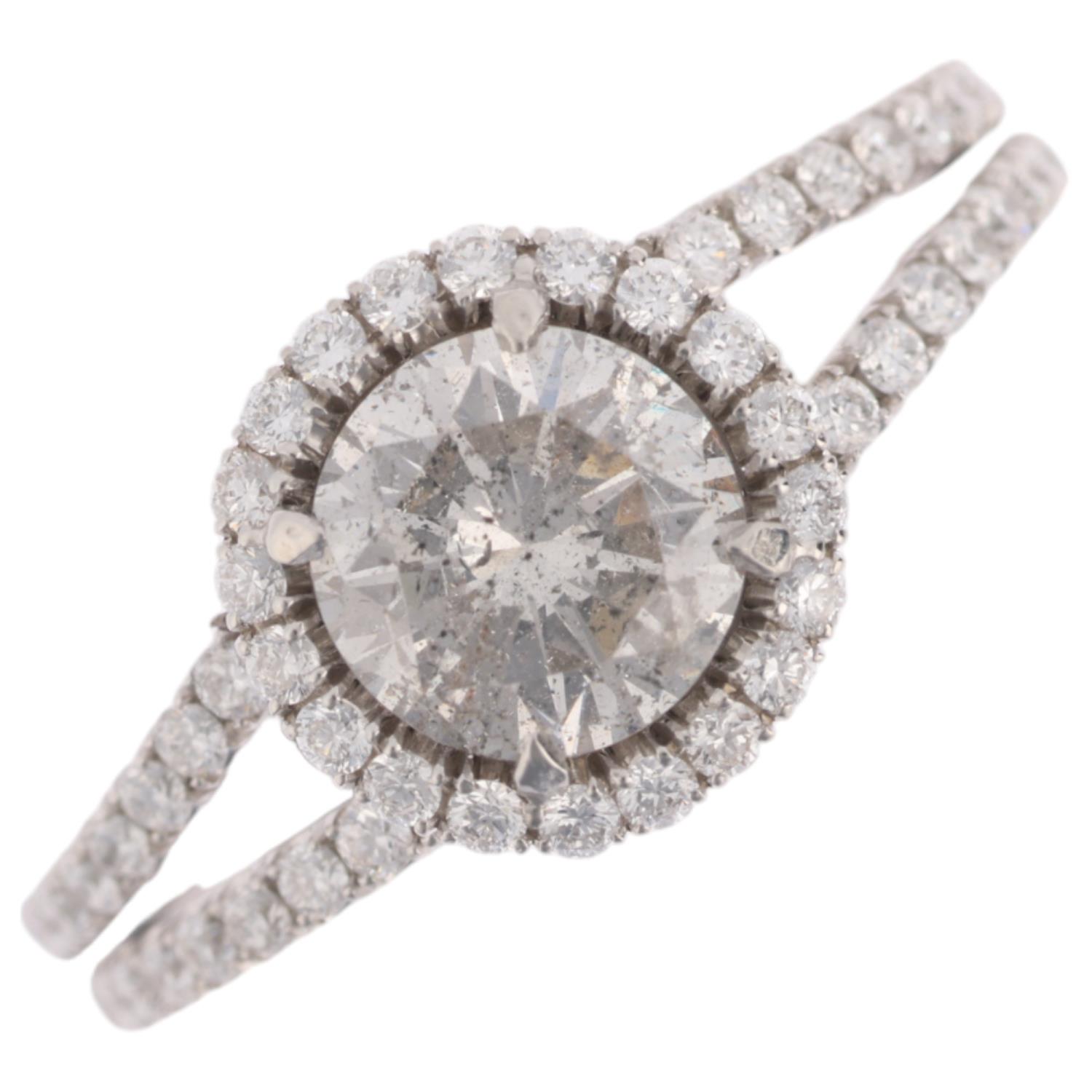 A modern diamond halo cluster ring, centrally set with 1ct modern round brilliant-cut diamond