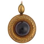 A Victorian Etruscan Revival garnet mourning locket pendant, circa 1880, centrally set with foil-