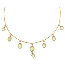 An Edwardian peridot fringe necklace, circa 1910, claw set with oval mixed-cut peridot drops, on