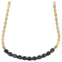 A 9ct gold sapphire line collar necklace, claw set with oval mixed-cut sapphires, 40cm, 8.1g No