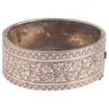 A Victorian sterling silver hinged bangle, engraved floral decoration, band width 24.5mm, internal