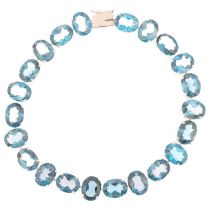 A modern 9ct white gold blue topaz tennis line bracelet, claw set with oval mixed-cut topaz, 20cm,