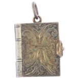 A Victorian novelty book photo locket pendant, the engraved covers opening to reveal arched interior