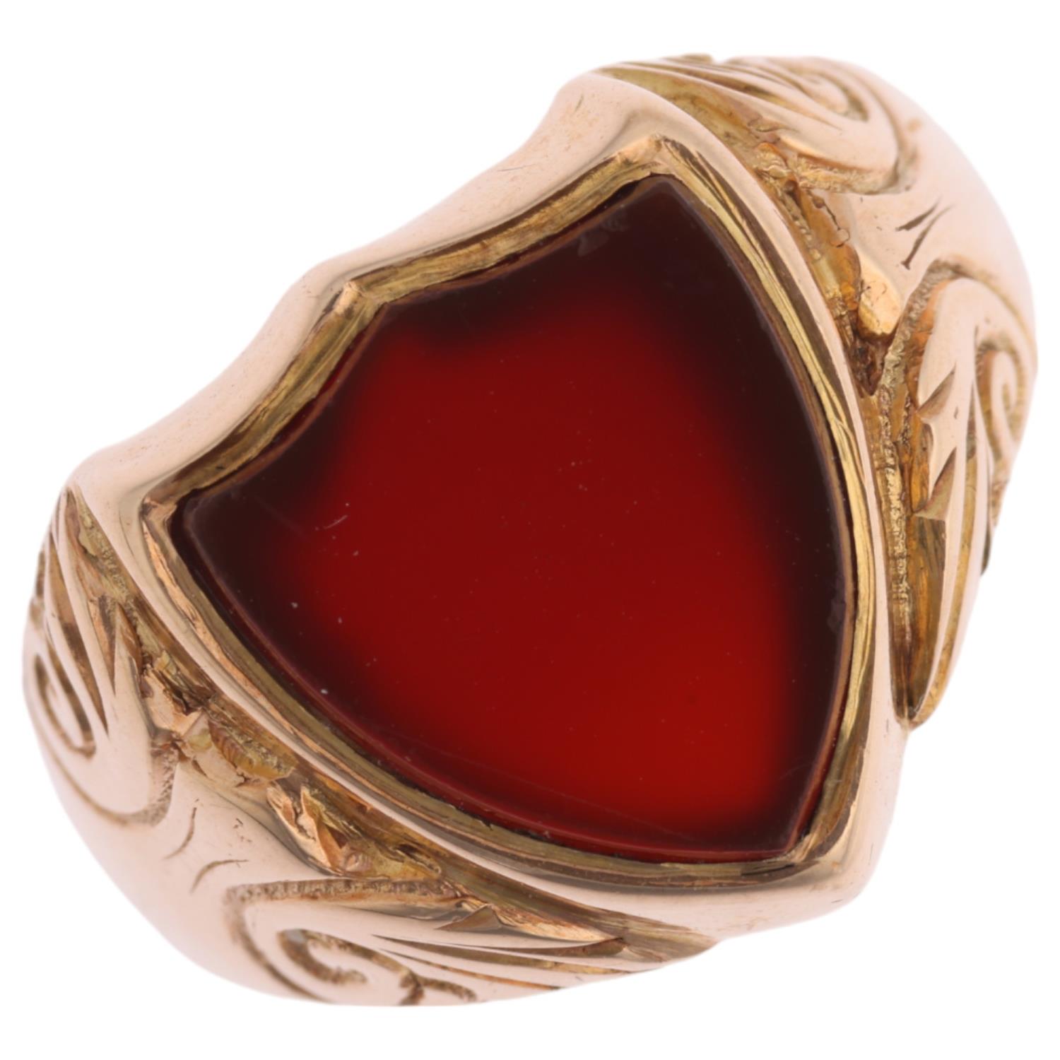 An early 20th century 9ct rose gold carnelian shield seal signet ring, Birmingham 1914, foliate