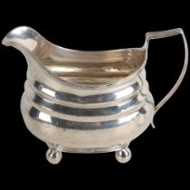 A George III silver cream jug, indistinct maker, London 1779, bulbous form with reeded rim and bun