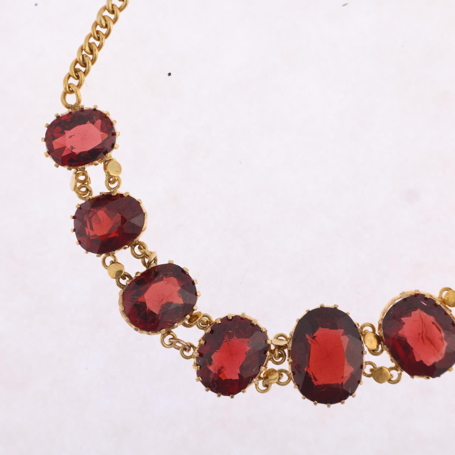 An Edwardian graduated garnet line bracelet, claw set with oval mixed-cut garnets, on curb link - Image 2 of 4