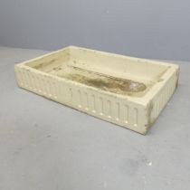 A glazed rectangular stone butler's sink, with fluted and armorial decoration. Coat of arms is