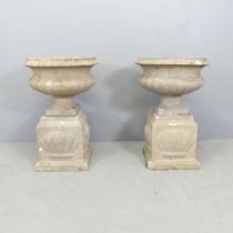 A pair of weathered concrete garden urns on plinth bases. Overall 45x66cm.