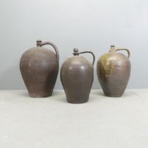 A graduated set of three terracotta flagons. Tallest 50cm.