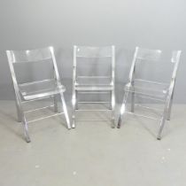 Three contemporary folding chairs, with lucite seats on chrome frames.