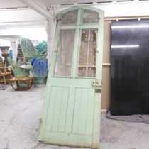 A large panelled arch top door, with opening glass panes and wrought iron decoration. 90x245cm.