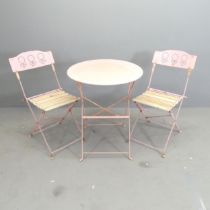 A circular painted metal folding bistro table, 59x71cm, and two matching chairs.