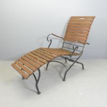 A vintage teak slatted steamer lounge chair on folding iron base.