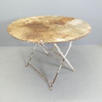 A French painted metal folding circular garden table. 97x71cm. Very heavily rusted, including a hole