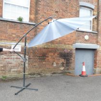 A large banana garden parasol with metal base. Height 255cm. Mechanical open/close mechanism in good