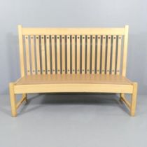 An Arts and Crafts style high backed bench in maple with leather seat, designed by Ronald Carter and