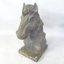 A heavy carved granite horse's head with attached plinth. H - 66cm. Good overall condition with no