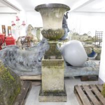 A weathered stone Campana style garden urn on plinth base, in four sections, with a plaque for the