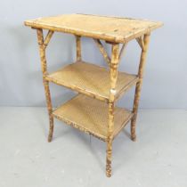 An early 20th century bamboo three-tier occasional table with applied rattan tops. 52x74x38cm.