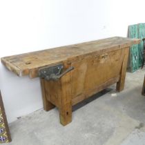 A vintage pine workbench, fitted with vice and fall-front cupboard under. 197x78x58cm.