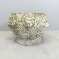 A weathered concrete garden urn with moulded decoration. 50x33cm.