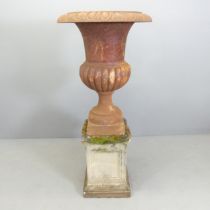 A large Victorian cast iron Campana style urn on stone plinth base. 59x126cm.