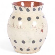 An Ewenny pottery vase, with cream and green spotted decoration, inscribed Blodau Hyfryd, H13.5cm