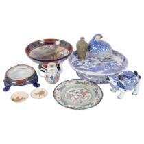 A collection of various ceramic items, including a small Chinese teapot, blue and white cake