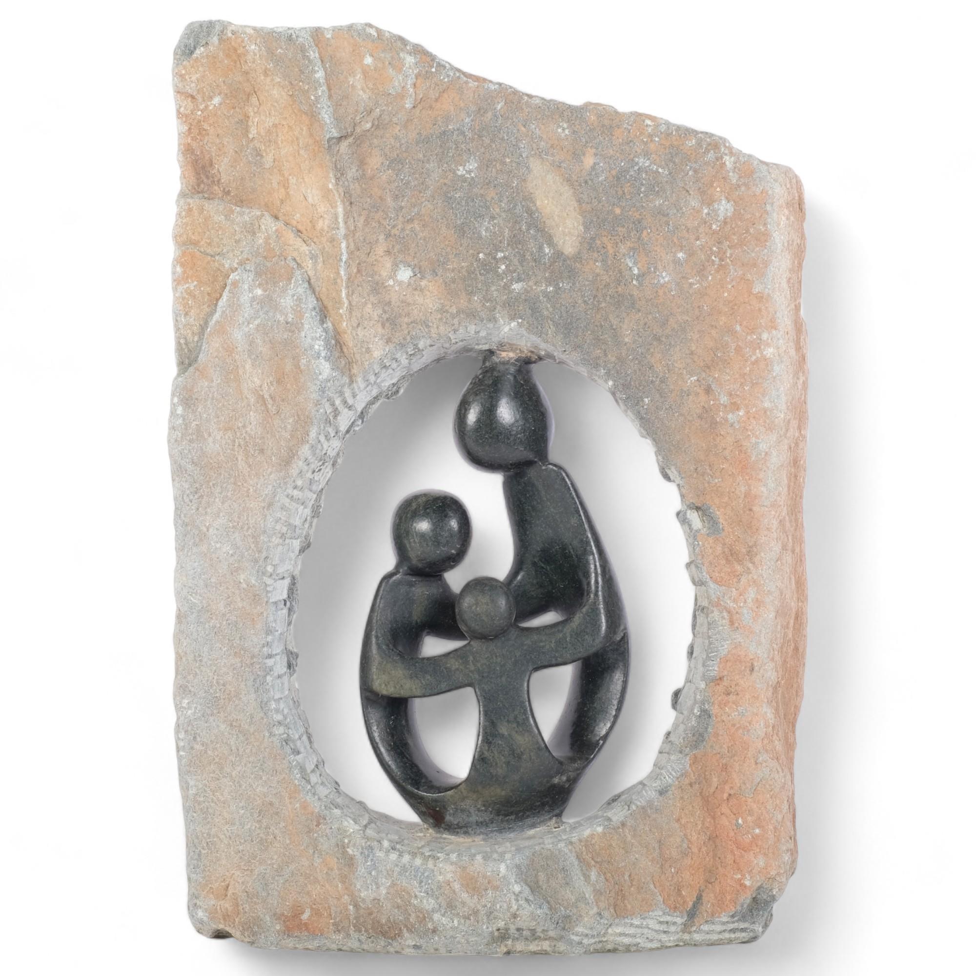 A carved stone sculpture depicting a framed mother and her children, H38cm