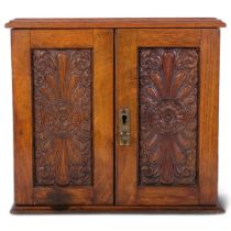 Vintage oak table-top cabinet, with carved panelled doors revealing drawer-fitted interior, with