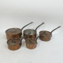 A set of five French copper saucepans with iron handles and lids