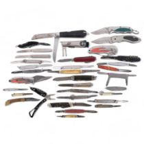 A collection of various penknives, including a silver example