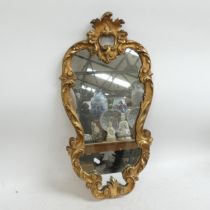 A gilt-framed Italian baroque style mirror. Height 73cm.