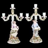 A pair of German porcelain candelabra, supported by figures with flower encrusted bowls, H43cm