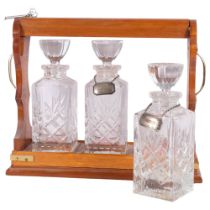 An oak 3-bottle tantalus, with crystal decanters, and 2 silver plated labels, L41cm