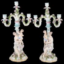 A pair of German porcelain candelabra, supported by Classical figures with putti, 51cm