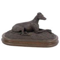 A cast-metal study of a seated Greyhound, on associated metal plinth, L18cm
