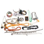 A tray of various costume jewellery, including an amber pebble panel bracelet, various necklaces,